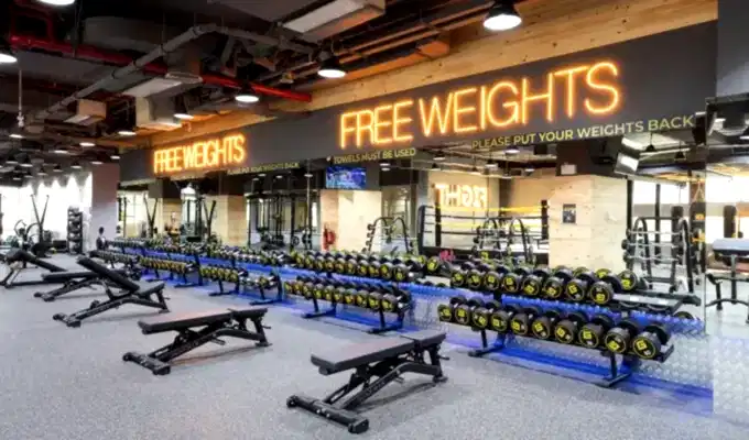 Gym free weight room equipped with dumbbells, barbells, and many more weightlifting equipments.